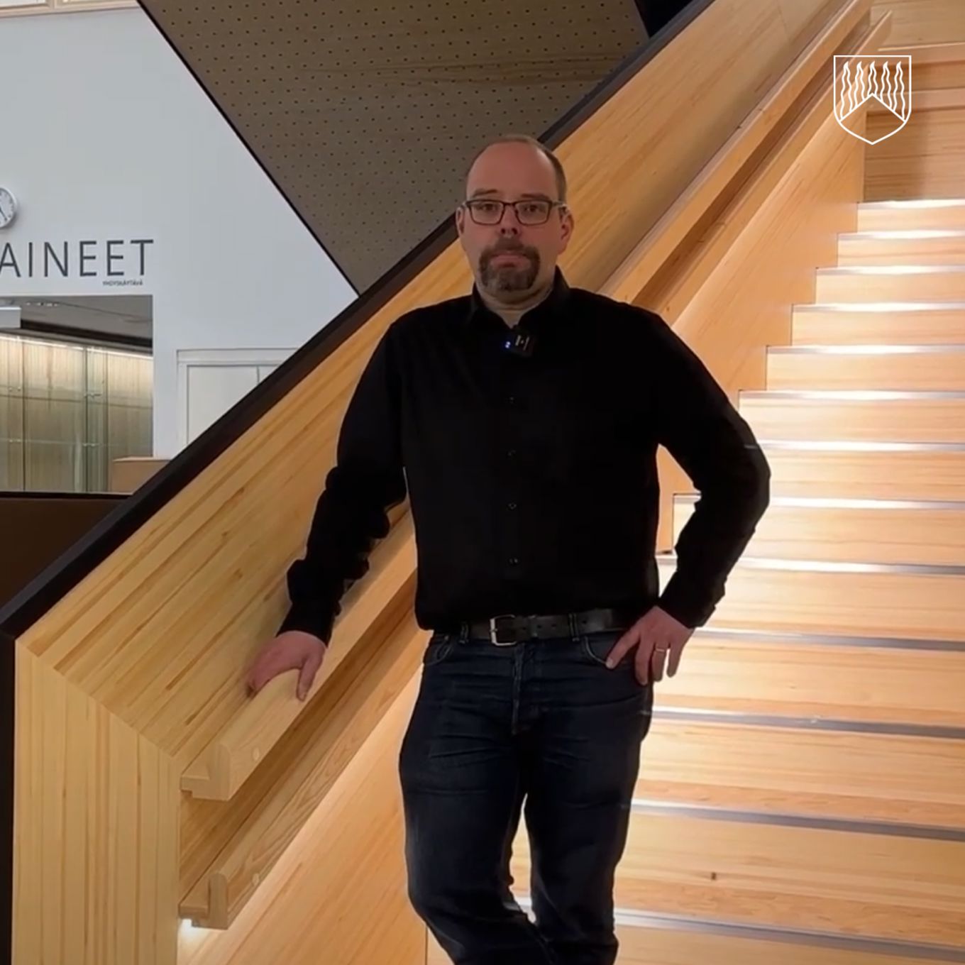 Kuvassa sivistysjohtaja Juha Väisänen monitoimitalon upeilla puuportailla.