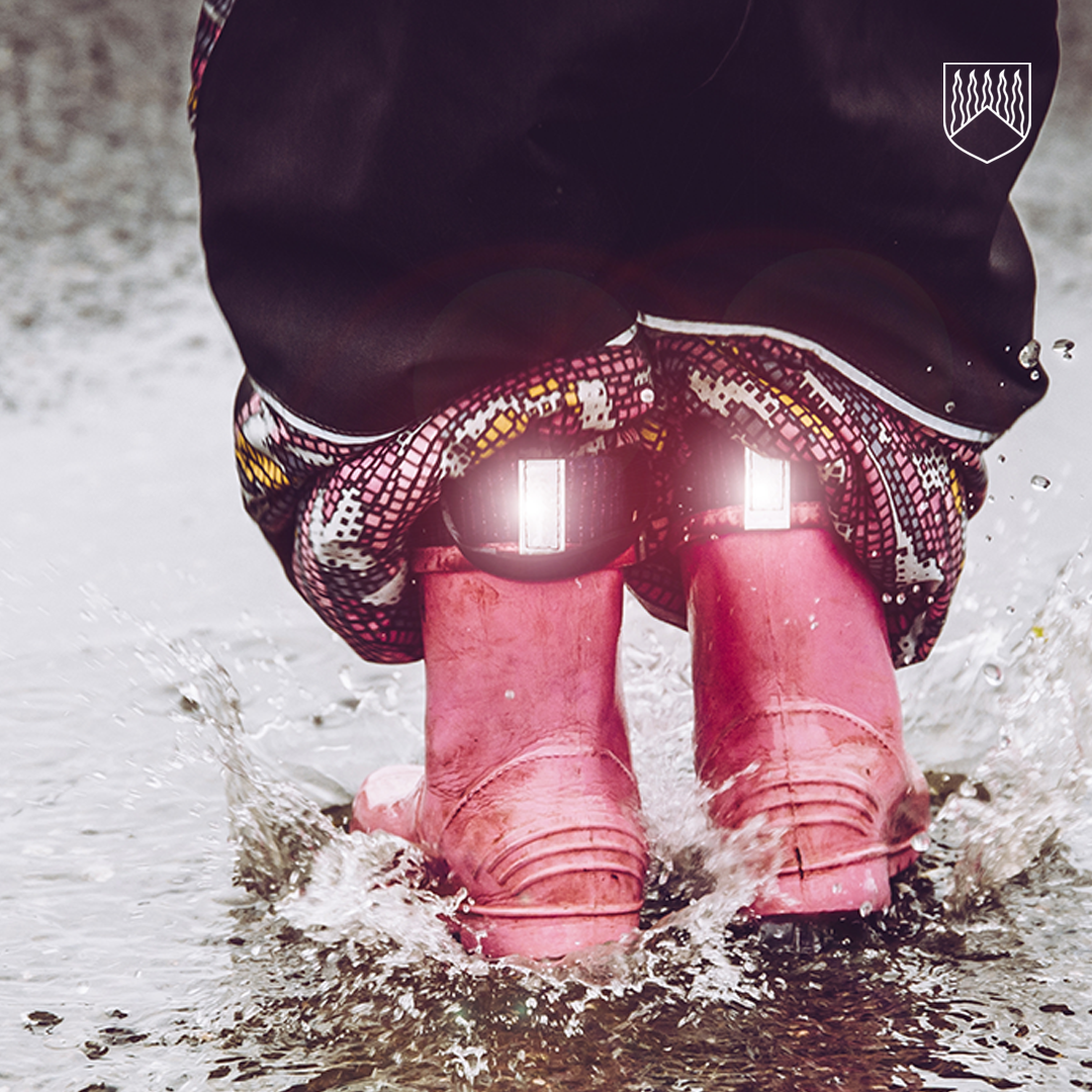 Pinkit kumisaappaat joissa loistavat heijastimet.